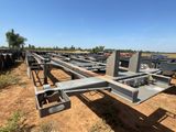 une grande structure métallique située au milieu d'un champ de terre battue