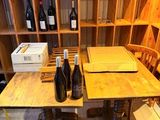 des bouteilles de vin et des cartons posés sur une table dans une cave à vin