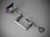 a metal clamp with a purple handle on a gray surface