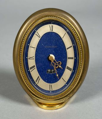une horloge dorée au cadran bleu posée sur une table