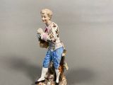 a figurine of a man with a basket of flowers