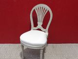 chaise en osier blanc devant un mur rouge