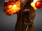 statue of a man holding a bunch of balloons with a flame coming out of it