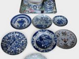 many blue and white plates and vases on the table