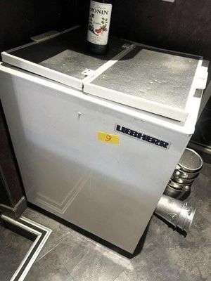 une bouteille de bière posée sur un petit réfrigérateur