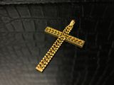 une croix en or posée sur une table noire