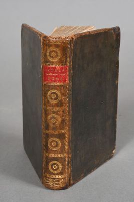 an old book sitting on top of a table next to a white wall