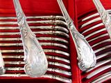 beaucoup de cuillères et de fourchettes en argent dans une boîte rouge