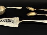 cinq cuillères et une cuillère doseuse posées sur une table