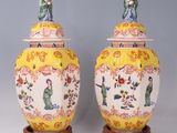 pair of yellow and white vases with asian figures on them