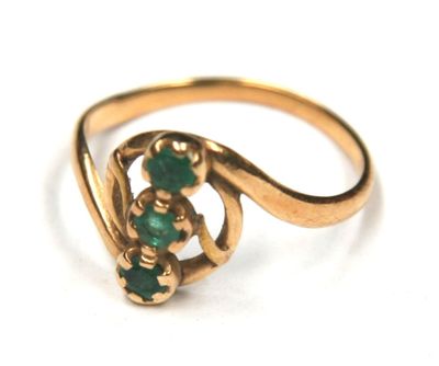 an image of a close up of a gold ring with green stones