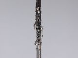 a black and silver clarinet on a clear surface