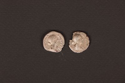 two roman silver coins, one of which has a head of a man and the other of a woman
