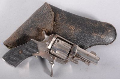 un pistolet dans un étui en cuir posé sur une surface blanche