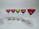 six wine glasses are lined up in a row on a white surface
