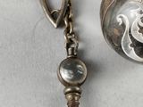 a close up of a silver pocket watch with a chain