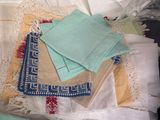a pile of folded cloths on top of a bed