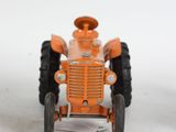 a small orange toy tractor on a white surface
