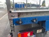 a blue flatbed truck with a license plate on the back of it