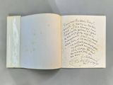 an open book with writing on it sitting on top of a table