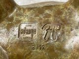 a bronze statue of a dog with a tag on it