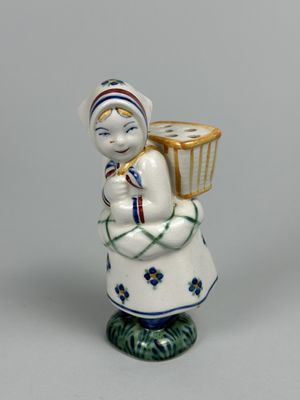 une figurine représentant une femme tenant un panier