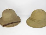 two hats are sitting side by side on a white surface