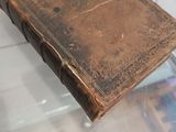 an old book on display on a glass table