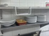 many plates and bowls stacked on a shelf in the kitchen
