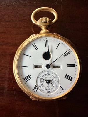 une montre de poche en or avec des chiffres romains sur le cadran