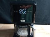 a black coffee maker with a digital clock on it
