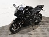une moto noire garée dans une pièce au sol en damier