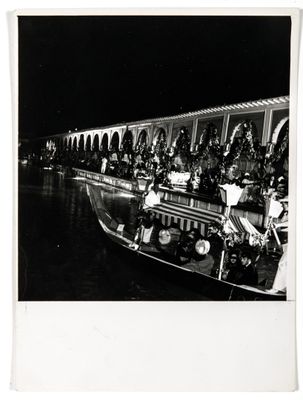 black and white photograph of a boat with people on it at night
