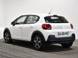 the rear end of a white car parked in a white room