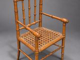 a wooden chair with a woven seat on a grey background