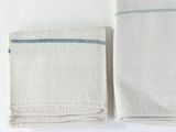 two towels folded on top of each other on a white surface