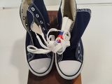 une paire de Converse bleues posées sur un bloc de bois