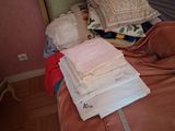 a pile of folded towels on a bed next to a mirror