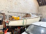 a small boat that is sitting in a garage next to a car