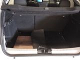 the back of a car with the trunk open and a laptop in the trunk