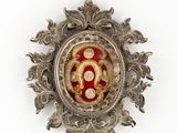 une image représentant une broche argentée et rouge sur fond blanc