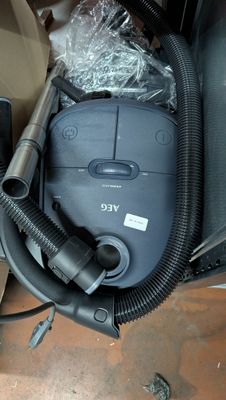 un aspirateur posé sur le sol à côté d'une boîte