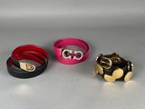 trois bracelets de couleurs différentes posés sur une table avec un fond argenté