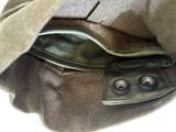 un sac marron contenant des boutons, posé sur une surface blanche