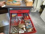 un tiroir rempli d'outils posé sur un établi dans un atelier