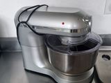 a silver mixer sitting on a kitchen counter next to a pot