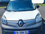 La petite camionnette blanche est garée sur un parking et porte une plaque d'immatriculation