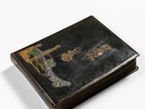 an old book with a painting on it sitting on a white surface