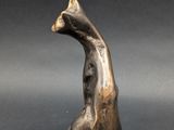 an image of a bronze sculpture of a bird on a black background