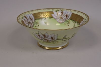 un bol blanc orné d'une bordure dorée et de motifs floraux